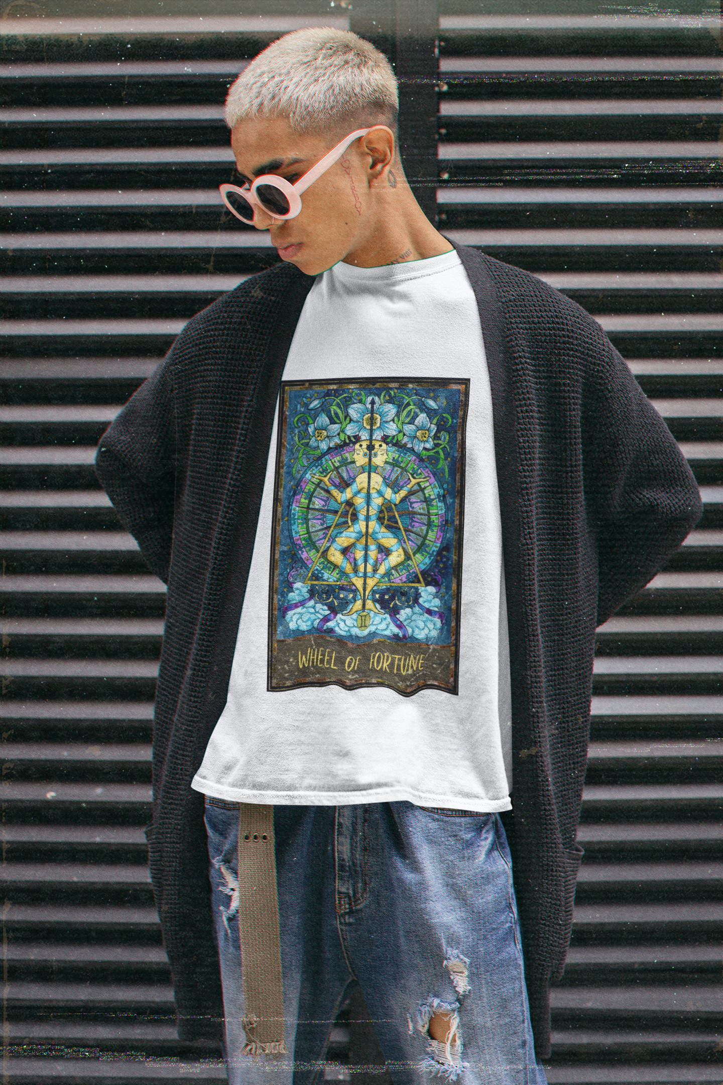 A man wearing a white Wheel of Fortune - Tarot Card T-Shirt, black long cardigan, and ripped dark blue jeans